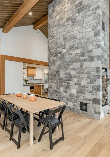 Stone chimney wall in an open dining room