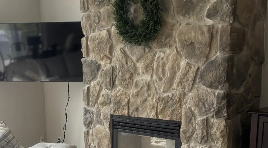 Warm-toned stone fireplace wall similar to a classic ledgestone look