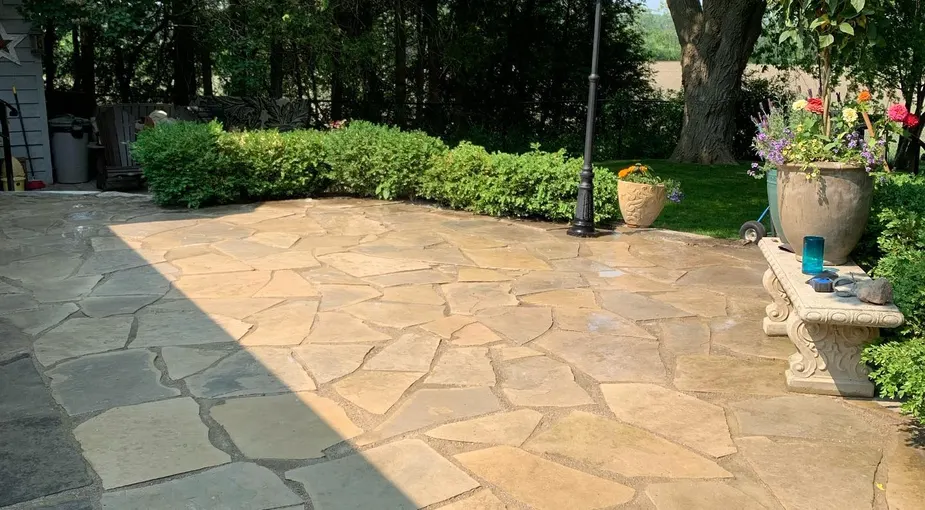 Flagstone patio installation with natural sandstone in a backyard