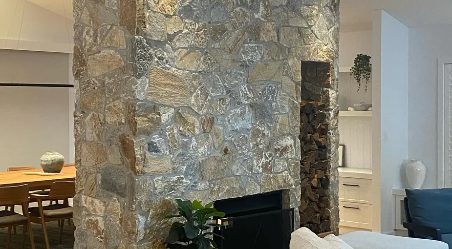 Natural stone veneer fireplace wall with irregular quarried stone