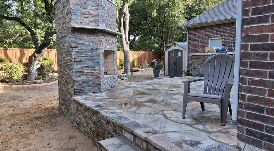 Outdoor kitchen masonry with a stone-clad BBQ island on a flagstone patio
