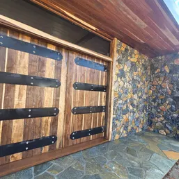 Fieldstone Veneer Wall Beside Wood Garage Doors, photo 2