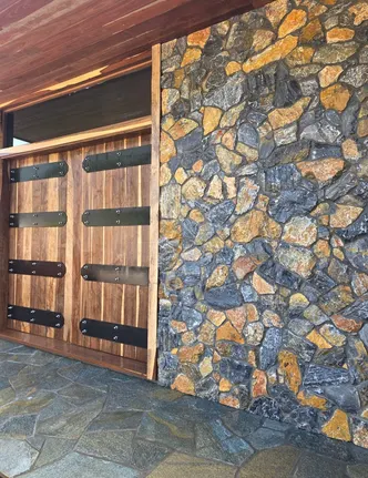 Fieldstone Veneer Wall Beside Wood Garage Doors