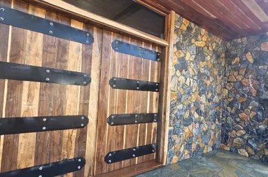 Fieldstone Veneer Wall Beside Wood Garage Doors detail