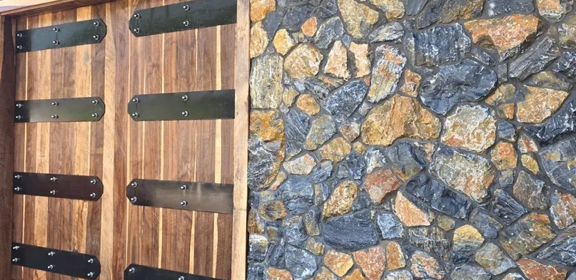 Fieldstone Veneer Wall Beside Wood Garage Doors