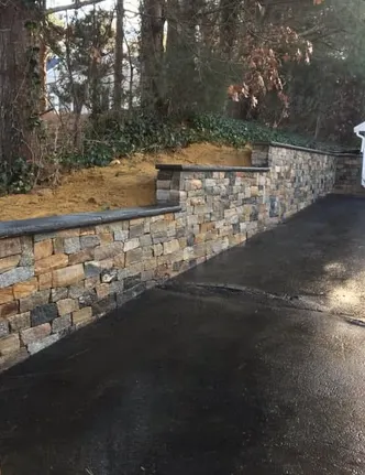 Stacked Stone Retaining Wall Along a Driveway