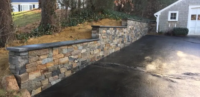 Stacked Stone Retaining Wall Along a Driveway