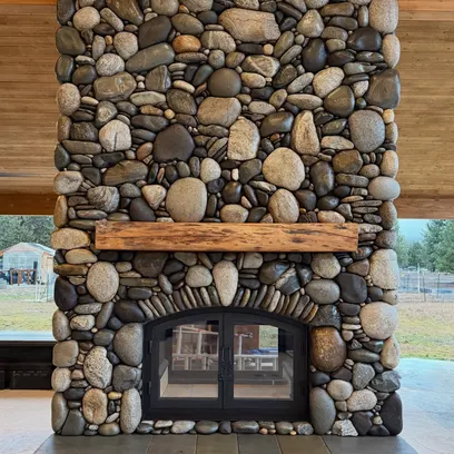River rock stone fireplace with timber mantel