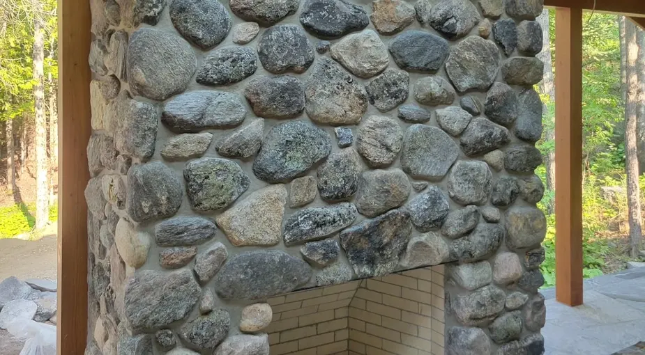 Stone-clad porch column installation with natural ledgestone