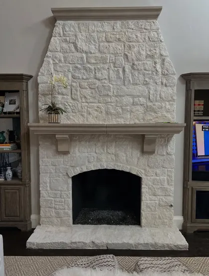 White stone fireplace with arched firebox