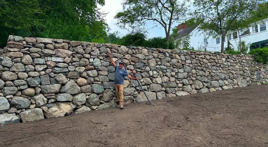 Stone wall repair and rebuilding of a natural stone retaining wall