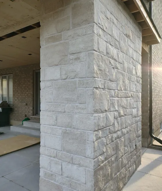 Light limestone outdoor fireplace on a covered patio